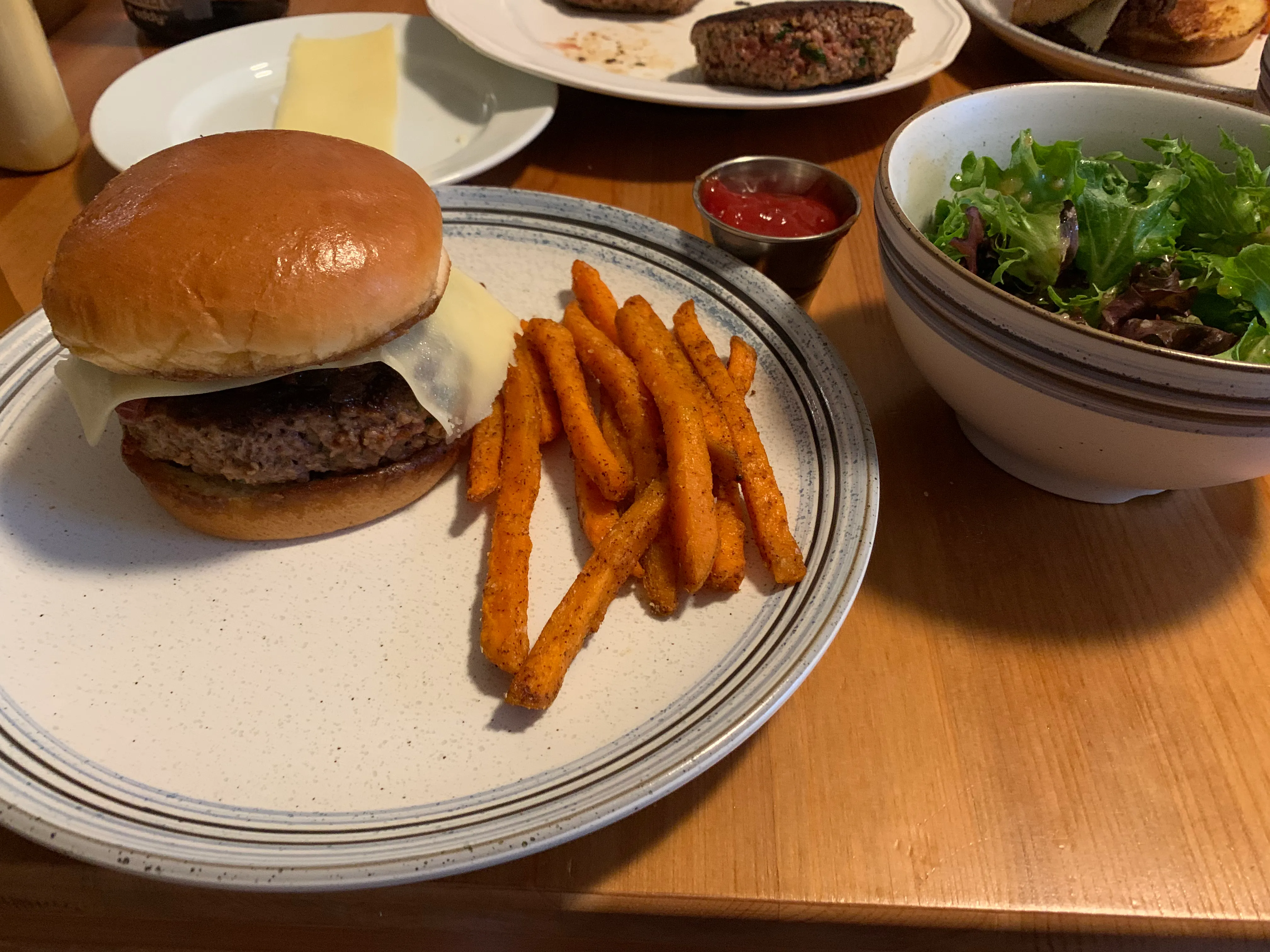 Finished veggie burgers with sweet potato fries and salad